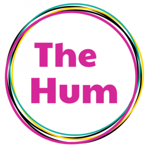 Bright pink text that reads "The Hum" surrounded by a multi-colored circle